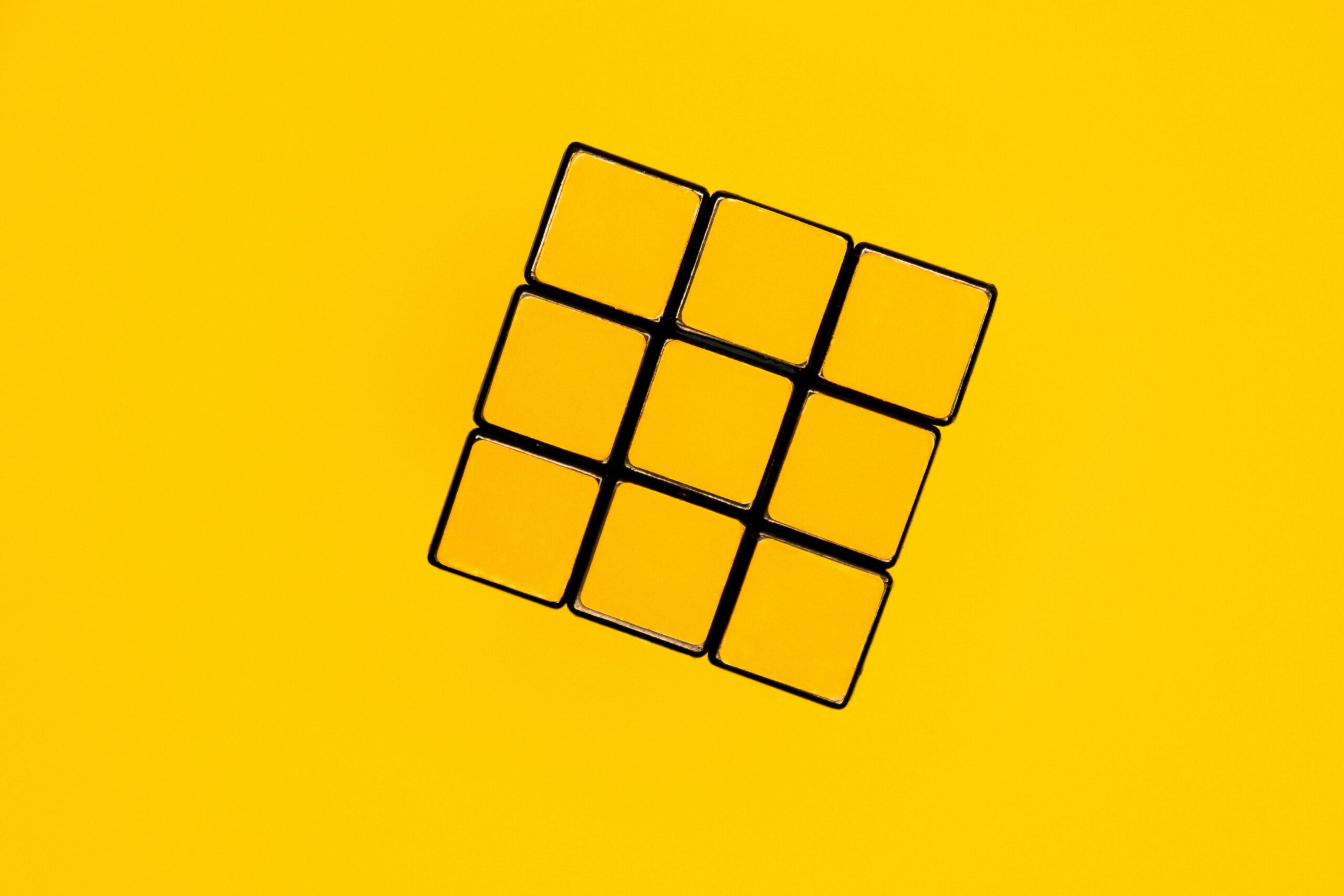 solved Rubik's cube with the yellow squares showing on a yellow background