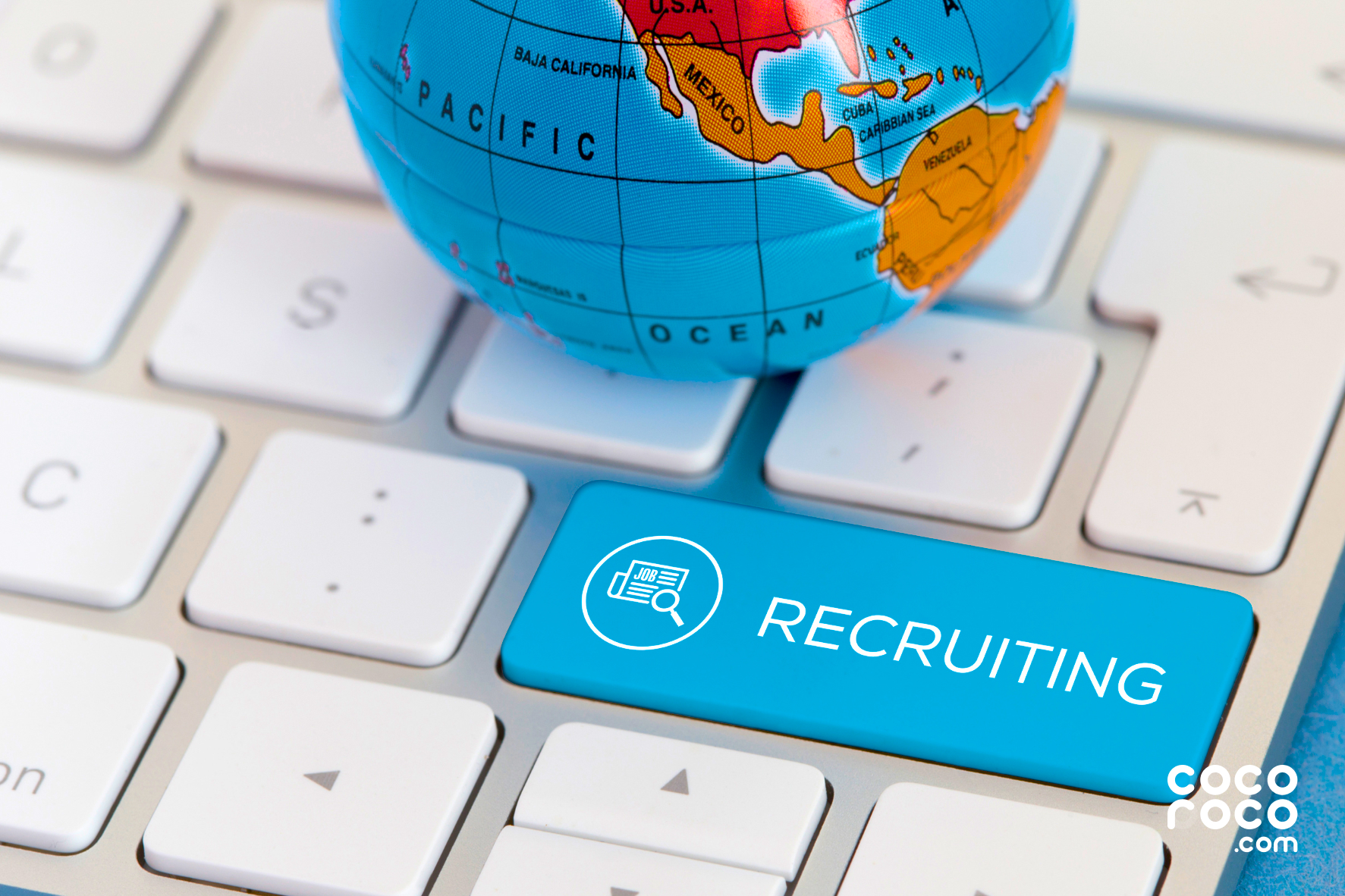 globe on top of mac keyboard with a button that says recruiting