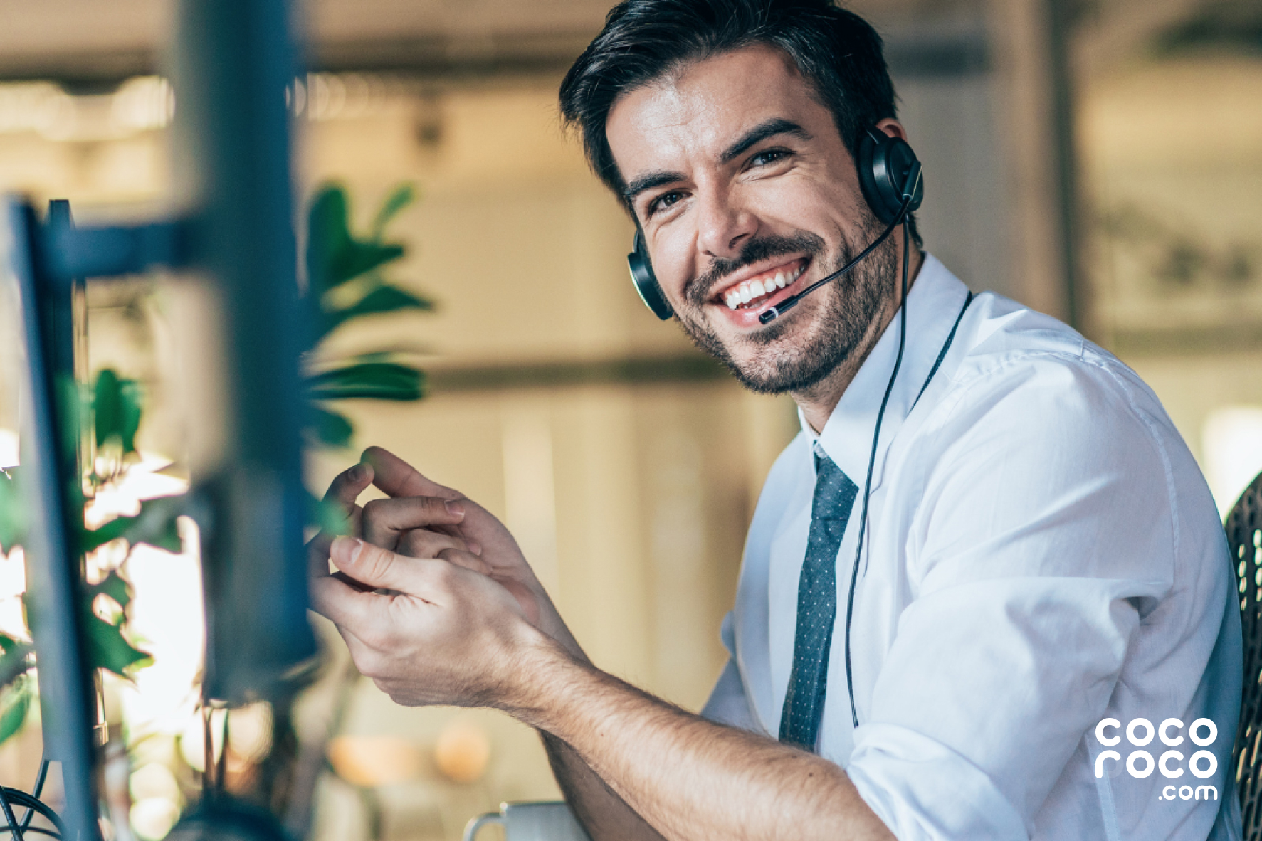 Image of a customer service representative at work, looking confident and professional. The representative is wearing a headset and is focused on the task at hand, with a friendly smile on their face. The image portrays a competent and approachable representative, ready to assist customers with their needs.