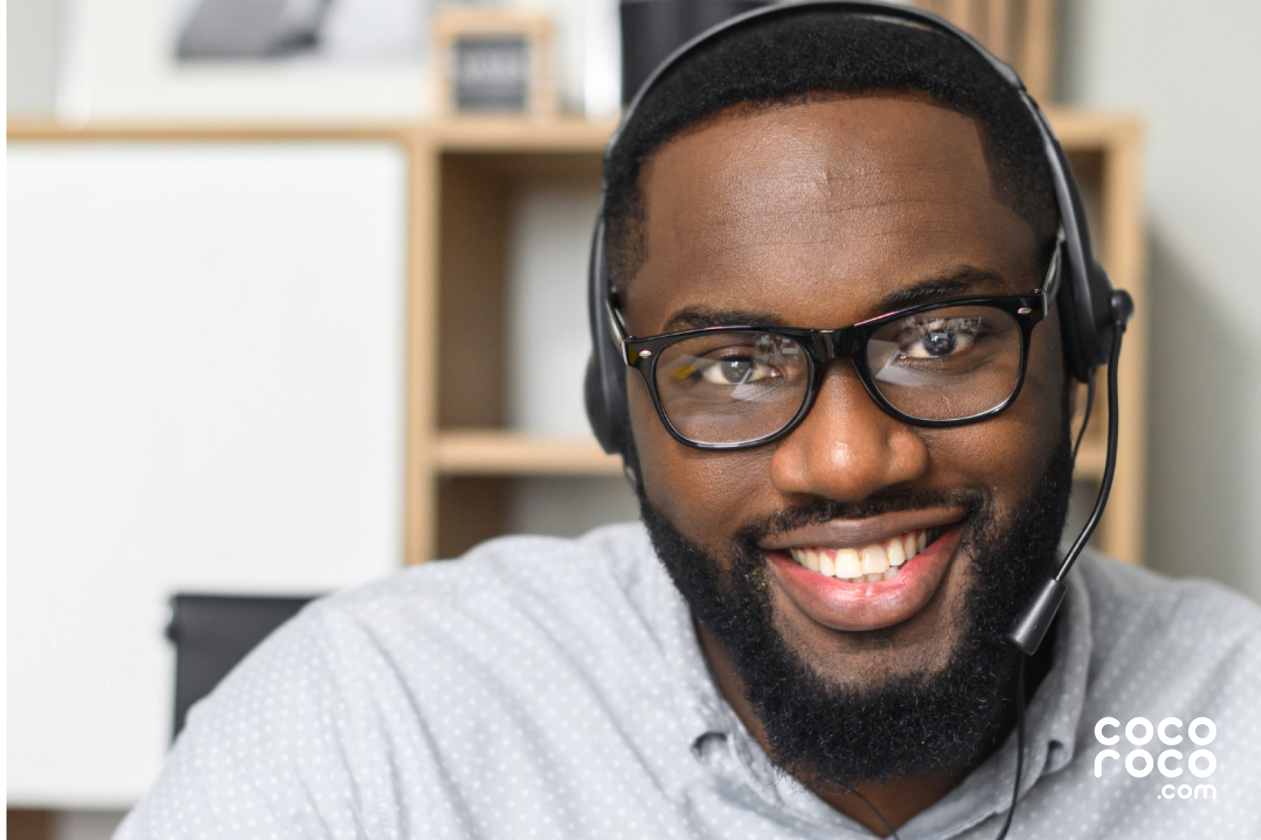 A customer service agent wearing a headset smiling and facing the viewer.